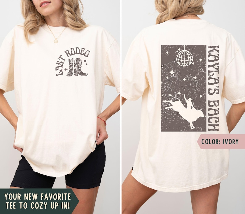 May include: Ivory-colored t-shirt with a rodeo-themed graphic on the front and back. The front features the text "LAST RODEO" with cowboy boots. The back displays "KAYLA'S BACH" with a bull riding design and disco ball.