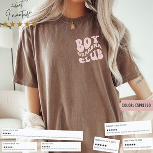 May include: A brown t-shirt featuring a pink retro-style graphic that reads "Boy Grandma Club". The t-shirt is modelled with the text "Exactly what I wanted!" and five gold stars above it. The text "COLOR: ESPRESSO" is at the bottom of the image.
