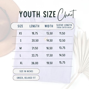K&ouml;nnte beinhalten: Wei&szlig;es T-Shirt mit einer Gr&ouml;&szlig;entabelle f&uuml;r Kindergr&ouml;&szlig;en. Die Tabelle enth&auml;lt Ma&szlig;e in Zoll f&uuml;r L&auml;nge, Breite und &Auml;rmell&auml;nge. Das Shirt wird als Unisex und entspannt beschrieben.