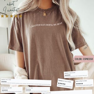 K&ouml;nnte beinhalten: Espressofarbenes T-Shirt mit dem wei&szlig;en Text "I'M LITERALLY DOING MY BEST". Das Shirt hat eine lockere Passform und kurze &Auml;rmel. Das Bild enth&auml;lt auch Kundenbewertungen.