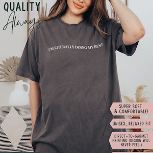 K&ouml;nnte beinhalten: Pfefferfarbenes T-Shirt mit dem wei&szlig;en Schriftzug "I'M LITERALLY DOING MY BEST". Das Shirt hat eine lockere Passform und besteht aus einem weichen, bequemen Material. Das Bild enth&auml;lt auch den Text "HIGH QUALITY Always".