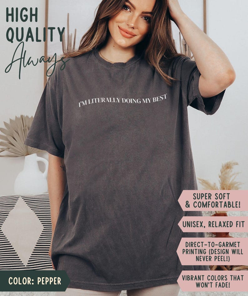 K&ouml;nnte beinhalten: Pfefferfarbenes T-Shirt mit dem wei&szlig;en Schriftzug "I'M LITERALLY DOING MY BEST". Das Shirt hat eine lockere Passform und besteht aus einem weichen, bequemen Material. Das Bild enth&auml;lt auch den Text "HIGH QUALITY Always".