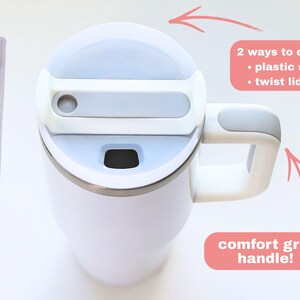 Puede incluir: Taza de viaje aislada blanca con tapa y asa grises. Incluye una pajita de pl&aacute;stico y una tapa giratoria para beber. La taza tiene un asa de agarre c&oacute;modo. El texto de la imagen dice: "2 ways to drink: plastic straw, twist lid" y "comfort grip handle!"