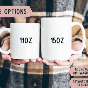 May include: Two white ceramic mugs, one labeled "110Z" and the other "150Z". The mugs are held by a person. Text on the image reads "SIZE OPTIONS", "MICROWAVE & DISHWASHER SAFE", and "ARTWORK IS PRINTED ON BOTH SIDES".