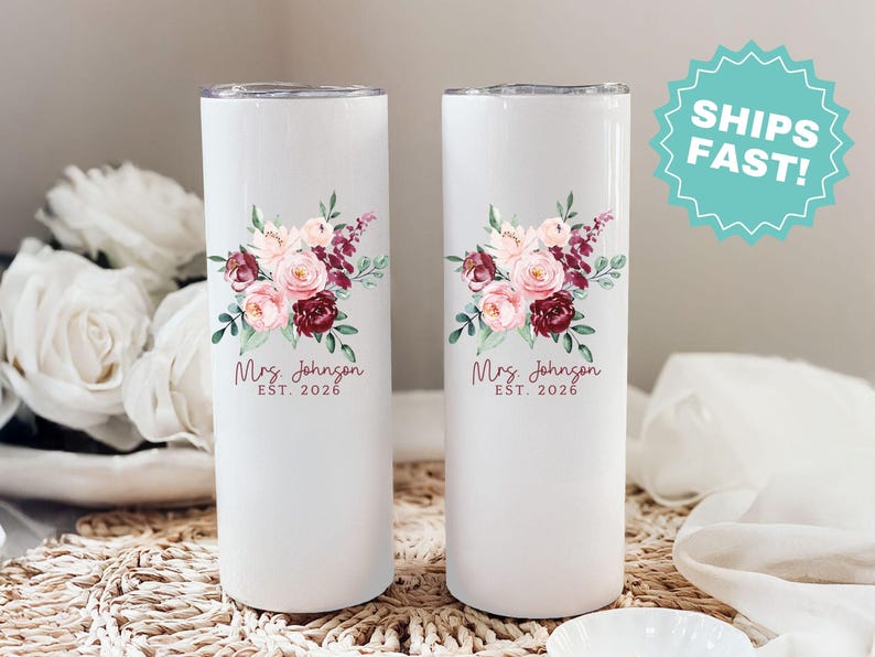 Puede incluir: Dos vasos aislados blancos con dise&ntilde;os florales. Cada vaso presenta un ramo de flores rosas y burdeos con hojas verdes. El texto "Mrs. Johnson EST. 2026" est&aacute; impreso debajo.