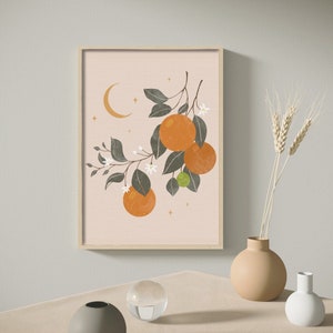 May include: A framed print of a stylized orange tree with green leaves, white flowers, and orange fruit. The background is a light pink color with a crescent moon and gold stars.