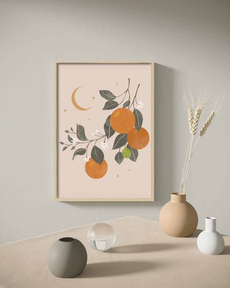 May include: A framed print of a stylized orange tree with green leaves, white flowers, and orange fruit. The background is a light pink color with a crescent moon and gold stars.