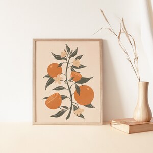 May include: A framed print of a stylized orange tree with green leaves, white flowers, and orange fruit. The background is a light beige color.