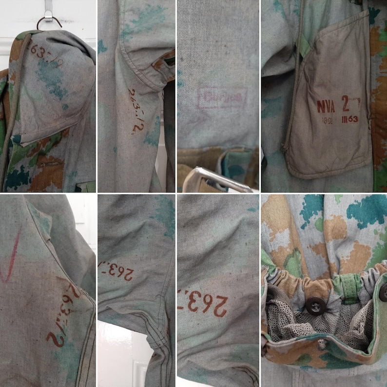 K&ouml;nnte beinhalten: Eine Tarnjacke mit verschiedenen Markierungen, darunter "NVA 2/62 11163" und Zahlen wie "263-1/2" und "763-3". Die Jacke hat ein gr&uuml;nes Netzfutter und einen Kordelzug in der Taille.