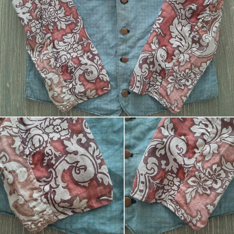 May include: A denim jacket with long sleeves featuring a floral pattern in shades of pink, white, and gray. The sleeves are made of a different fabric than the jacket itself.