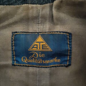 May include: A blue label with a gold triangle containing the letters "AT" and the text "Die Qualit&auml;tsmarke".