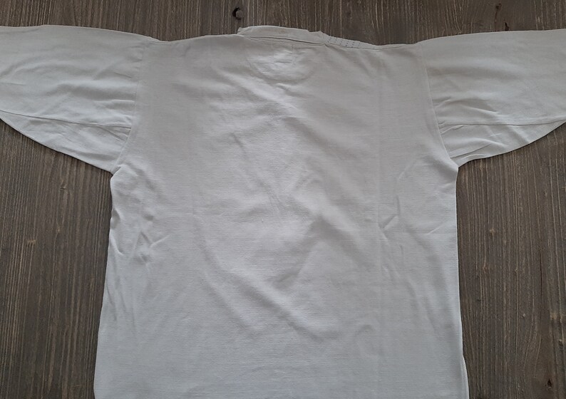 Op de afbeelding: Een effen wit longsleeve shirt met een ronde hals.
