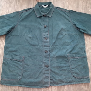 May include: A dark teal work jacket with two chest pockets and button closures.