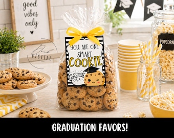 May include: A clear cellophane bag filled with chocolate chip cookies, tied with a yellow ribbon and a tag that reads "You Are One Smart Cookie." Other graduation party decorations include popcorn, cups, and straws.