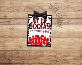 May include: Black and white striped sign with a red bow on top. The sign says "Hip Hip Hooray" and "It's Competition Day!" with a silhouette of cheerleaders in red.