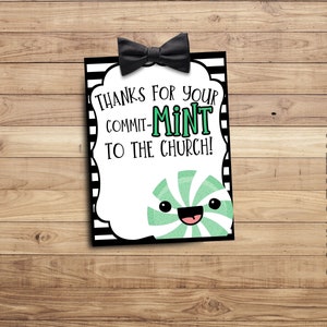 Könnte beinhalten: Eine weiße Karte mit schwarzen Streifen und einer schwarzen Schleife oben. Die Karte trägt den Text "Danke für Ihr Engagement in der Kirche!" und ein Cartoon-Pfefferminzbonbon mit einem lächelnden Gesicht.