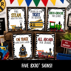 May include: Five rectangular signs in dark wooden frames, each featuring a train-themed illustration and religious text. The signs display phrases like Full Steam Ahead for Jesus, Jesus is our Ticket to Heaven, Choo-Choose the Lord, On Track with God's Word, and All Aboard for Jesus, with colorful train graphics.