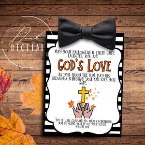 May include: A white card with black and orange stripes and a black bow at the top. The card has a message that says "May your Halloween be filled with laughter, joy, and God's Love. As you enjoy the fun, may his blessings surround you and keep you safe. For he will command his angels concerning you to guard you in all your ways. -Psalm 9:11"