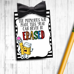 May include: Black and white striped card with a black bow tie at the top. The card says "The memories we made this year can never be ERASED". There are two cartoon characters, a pencil and an eraser, on the card.