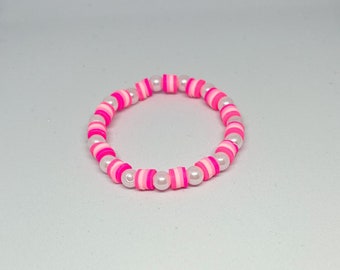 May include: A pink and white beaded bracelet with alternating colors and white pearl beads.