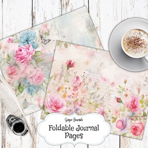 May include: Two printable journal pages with a vintage floral design. The pages feature watercolor illustrations of pink and blue flowers, leaves, and vines on a white background with a distressed texture. The text "Ginger Journals Foldable Journal Pages" is printed at the bottom of the pages.