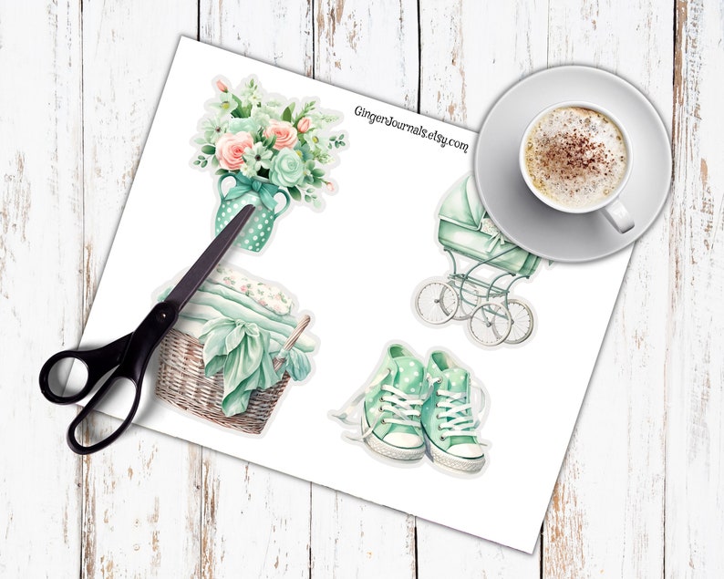 May include: A sheet of stickers featuring watercolor illustrations of baby-themed items. Includes a baby carriage, a basket of blankets, a bouquet of flowers, and a pair of sneakers. The text "GingerJournals.etsy.com" is visible.