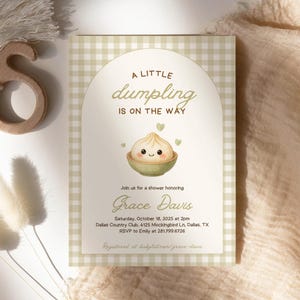 May include: Baby shower invitation with a light green gingham pattern background. The invitation features the text "A LITTLE dumpling IS ON THE WAY" with a dumpling illustration. Details include the honoree's name, date, time, and location.
