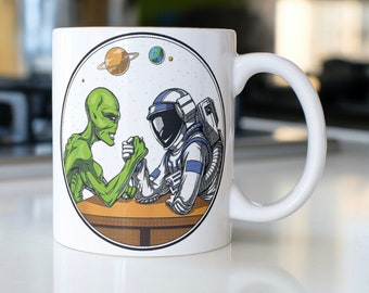 Funny Alien arm wrestling an astronaut coffee mug