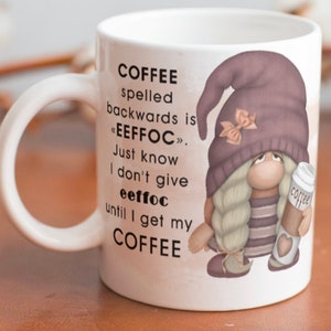 May include: White ceramic coffee mug with a black and white graphic of a gnome holding a coffee cup. The text on the mug reads "COFFEE spelled backwards is «EEFFOC». Just know I don't give eeffoc until I get my COFFEE".