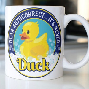Funny rubber duck coffee mug stating,&quot;Dear AutoCorrect...It&#39;s Never DUCK&quot;
