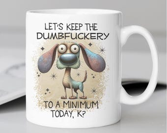 May include: White ceramic mug with a cartoon dog illustration and the text "LET'S KEEP THE DUMBFUCKERTY TO A MINIMUM TODAY, K?". The dog has large ears, a blue nose, and a whimsical design.
