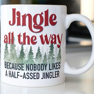 May include: White ceramic mug with a red and black design. The mug reads "Jingle all the way because nobody likes a half-assed jingler".