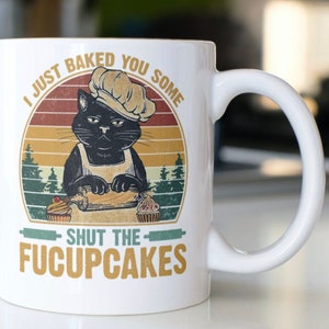 Funny Cat Coffee mug stating “I Just Baked You Some Shut The FUCUPCAKES” on both sides of the mug.