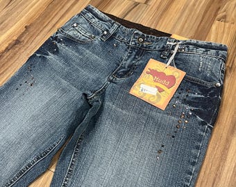 May include: Blue denim jeans with rhinestones and a Mudd brand tag. The jeans have a faded look and are distressed.