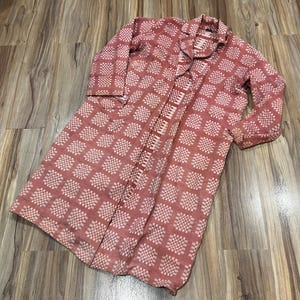 May include: A long, open-front coat in a dusty rose color with a repeating checkered pattern in a lighter shade. The coat has long sleeves and a collared neckline. The fabric appears to be lightweight, suitable for layering.