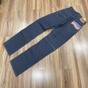 Könnte beinhalten: Eine dunkelblaue Jeanshose mit einem braunen Leder-Patch, auf dem "Lee" und "The Original Straight Leg" steht.