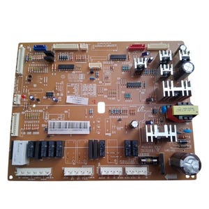 May include: A brown circuit board with various electronic components, including capacitors, resistors, and integrated circuits. The board has multiple connectors and a warning label. The components are arranged on a rectangular surface.