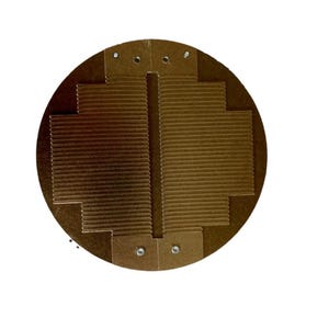 May include: A round, brown, corrugated metal disc with a central slit and multiple small holes around the edge.