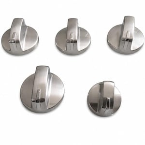May include: A set of five circular stove control knobs with a metallic silver finish. Each knob features a raised vertical handle with a central groove, providing a grip for rotation. The knobs are arranged in a group of three above and two below.