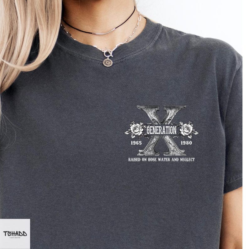 Pu&ograve; includere: Una maglietta grigia scura con una stampa grafica bianca di una lettera X stilizzata con il testo "Generation X 1965-1980 Raised on Hose Water and Neglect".