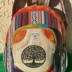 Puede incluir: Una mochila de cáñamo multicolor con un diseño de árbol de la vida y el texto "HIMALAYAN HE.MP THO FREE MADE IN NEPAL".