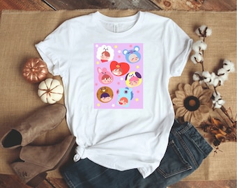 May include: White t-shirt with a pink background featuring cartoon characters with different colored animal heads. The characters are arranged in a grid pattern with white stars scattered around them.