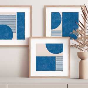 Può includere: Tre stampe d'arte astratta incorniciate con un design minimalista che presenta forme geometriche in tonalità di blu e beige.