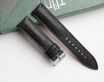 May include: Two black leather watch straps with silver buckles. One strap has stitching and the other has holes.