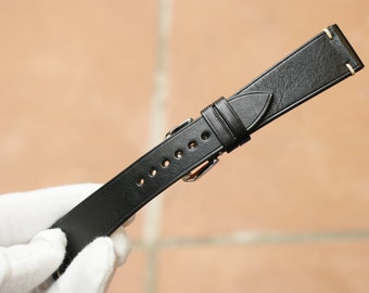 May include: Black leather watch strap with stitching detail and a silver buckle.