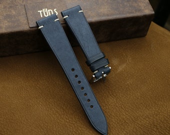 May include: Two dark blue leather watch straps with white stitching and silver hardware.