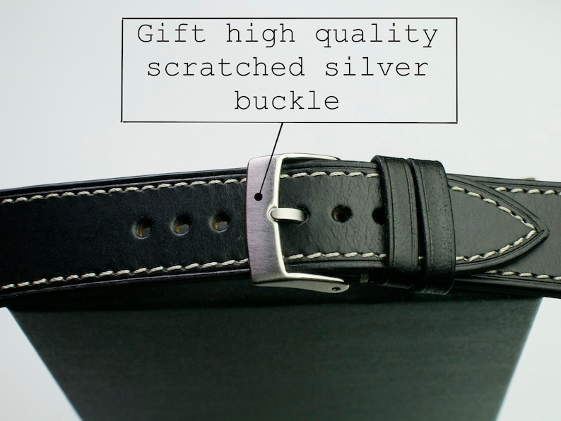 Peut inclure: Bracelet de montre en cuir noir avec des coutures blanches et une boucle argent&eacute;e. La boucle a une finition ray&eacute;e. "Gift high quality scratched silver buckle" est &eacute;crit en blanc sur un rectangle noir.