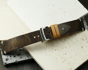 May include: A brown leather watch strap with a light brown stitching detail and a silver buckle.