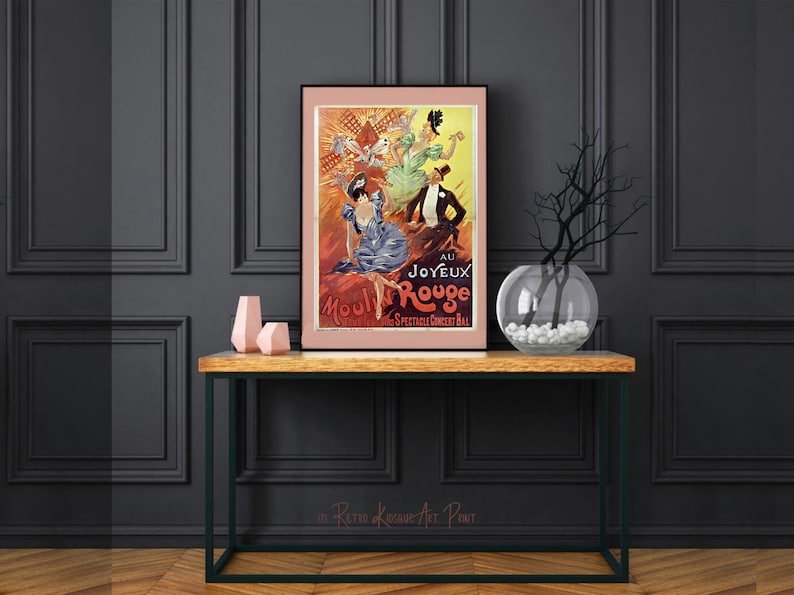 May include: A vintage poster advertising the Moulin Rouge cabaret in Paris, France. The poster features a red and orange background with a group of women in colorful costumes. The text on the poster reads "Au Joyeux Moulin Rouge."