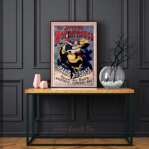 May include: A vintage poster advertising the Moulin Rouge in Paris, France. The poster features a couple dancing, with the woman wearing a yellow dress and the man wearing a red shirt. The poster is framed and hanging on a wall.